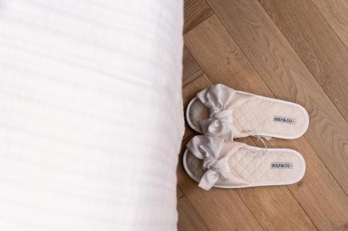 a pair of white shoes sitting next to a bed at Savyon View Tower - Isrentals in Jerusalem