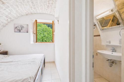 une chambre blanche avec un lit et un lavabo dans l'établissement MAS LE CORBERY, à Largentière