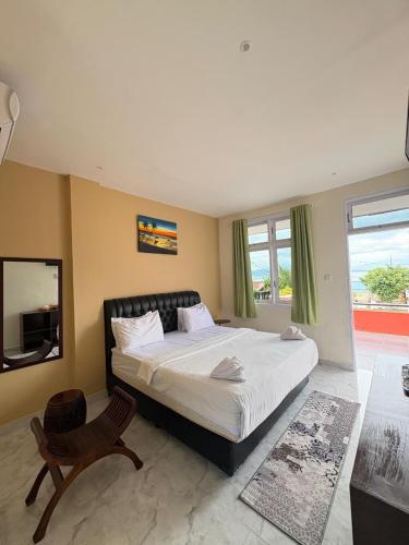 a bedroom with a large bed and a window at Hotel Ompu Herti in Balige