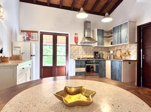 a kitchen with a large wooden table with a bowl on it at Milharadas - A Private Oasis in the Alentejo in Odemira