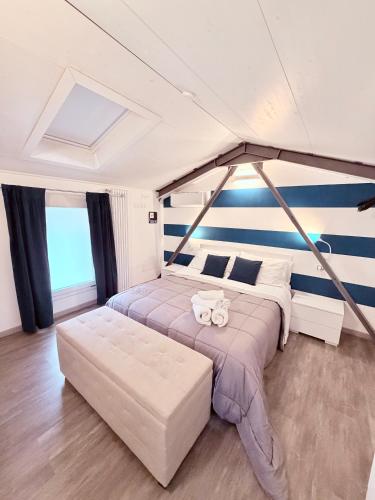 a bedroom with a large bed with a blue and white striped wall at Ama Collection Esclusive Spa in Bologna