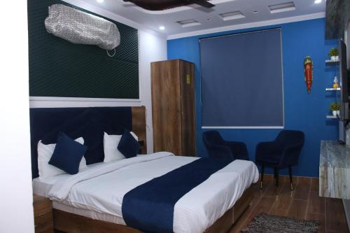 a bedroom with a bed with blue walls and chairs at Red Leaf Hotel in Māler Kotla