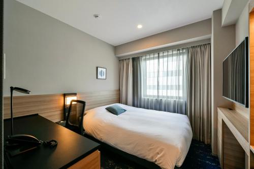 a hotel room with a bed and a desk at Hotel JAL City Miyazaki in Miyazaki