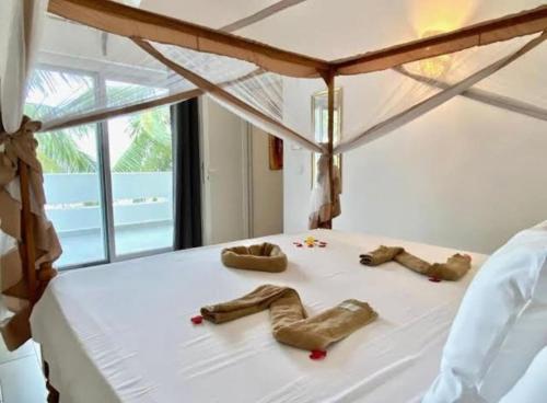 a bedroom with a bed with wooden shoes on it at TWIGA APARTHOTEL by Sofia Collection in Pwani Mchangani