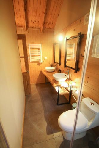 a bathroom with two sinks and a toilet at Piedra Nevada in Malalcahuello