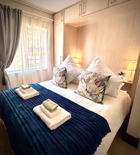 a bedroom with a bed with towels on it at Klein Geluk Cottage in Stellenbosch