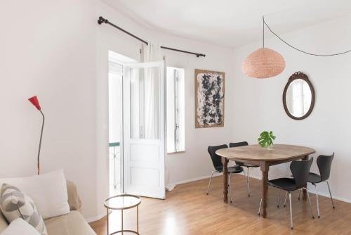 ein weißes Wohnzimmer mit Tisch und Stühlen in der Unterkunft TRACES Lagos in Lagos