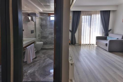 ein Wohnzimmer mit Sofa und ein Badezimmer in der Unterkunft Buca Mat Hotel By Tahtalı in Izmir