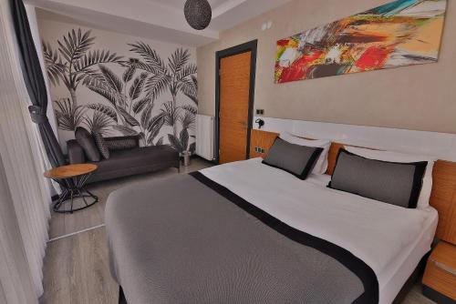 ein Schlafzimmer mit einem großen Bett und einer Couch in der Unterkunft Buca Mat Hotel By Tahtalı in Izmir