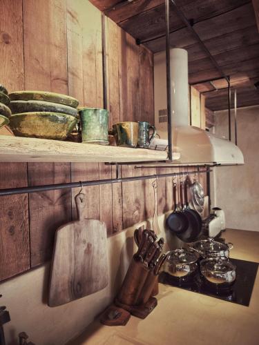 a kitchen with a shelf with pots and pans at Moulin des Bergères in Mouriès