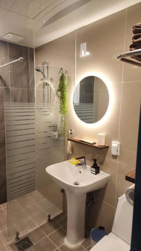 a bathroom with a sink and a shower with a mirror at The YoGwan in Suwon