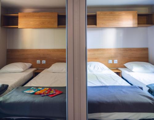 a bedroom with two beds and a mirror at L'Oasis des Dombes in Ambérieux-en-Dombes