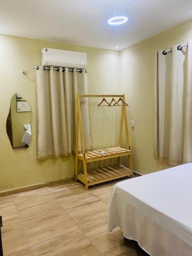 a room with a bed and a shower and a window at Casa em Praia de Flecheiras in Trairi