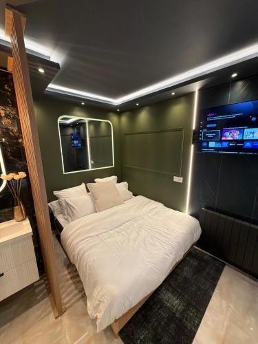 a bedroom with a large white bed in a room at Onyx Suite Jacuzzi Privatif in Villejust