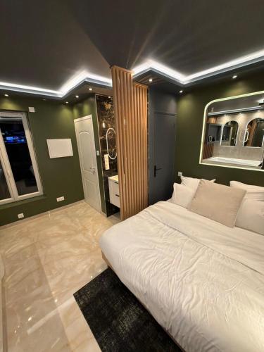 a bedroom with a large white bed in it at Onyx Suite Jacuzzi Privatif in Villejust