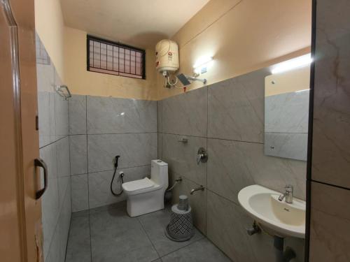 a bathroom with a toilet and a sink at Hill View Residency in Kalpetta