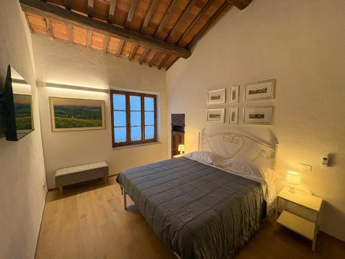 a bedroom with a large bed and a window at Tuscany Charme Apartments in Asciano