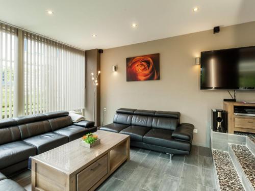 a living room with a couch and a flat screen tv at Luxury Villa with Sauna and bubble bath in Middelkerke