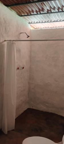 a bathroom with a toilet and a window at Finca Hostal Eva Maria in Santa Marta