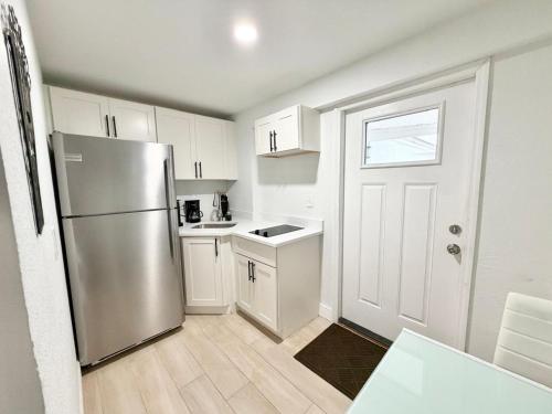 a kitchen with a stainless steel refrigerator and white cabinets at Cozy Guesthouse Downtown Tampa in Tampa