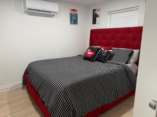 a bed with a red headboard in a bedroom at Cozy Guesthouse Downtown Tampa in Tampa