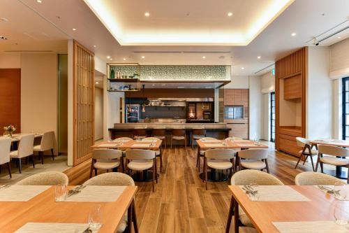 a restaurant with wooden tables and chairs and a bar at Hotel JAL City Miyazaki in Miyazaki