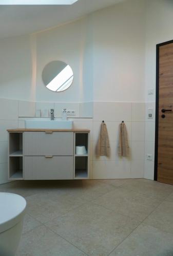 a bathroom with a sink and a toilet and a mirror at Gipfelblick Weißenbacher in Übersee