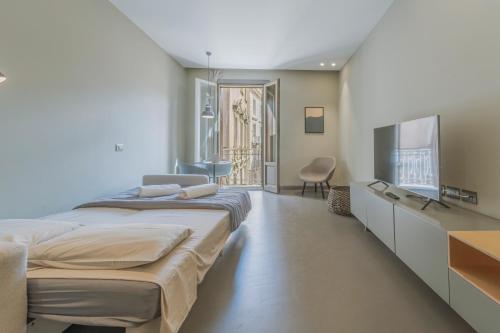 a bedroom with a large bed and a flat screen tv at Torrearsa street 35 in Trapani