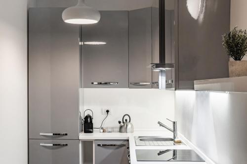 a kitchen with white cabinets and a sink at Gerusalemme's Nest - In the heart of the city in Milan