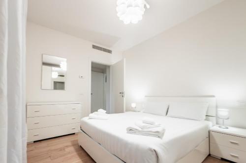 a white bedroom with a white bed and a mirror at Gerusalemme's Nest - In the heart of the city in Milan