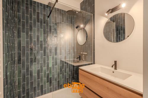 a bathroom with a sink and a glass shower at Velasquez 0303 in Nieuwpoort