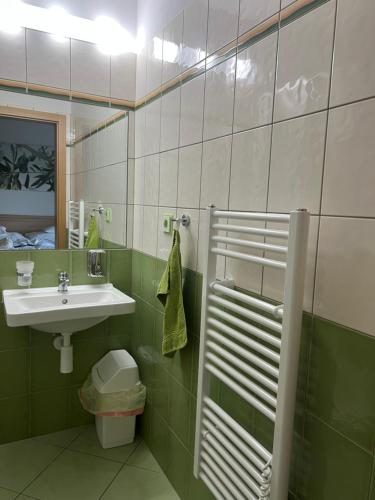 a green and white bathroom with a sink and a toilet at Opilý Sklep č3 in Velké Pavlovice