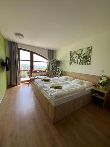 a large bedroom with a large bed and a table at Opilý Sklep č3 in Velké Pavlovice