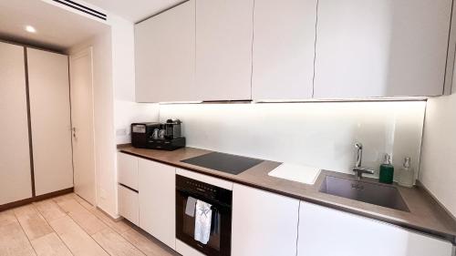 a kitchen with white cabinets and a sink at Casa Elisabeth in Portovenere