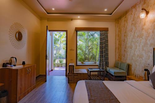 a hotel room with a bed and a bathroom at Flying Sparrow Riverside Resort in Dhikuli