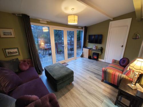 a living room with a couch and a chair at Crofters Cabin in Caernarfon