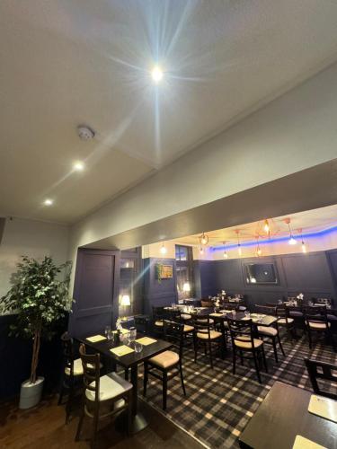a restaurant with tables and chairs in a room at The Old Cross Inn in Blairgowrie