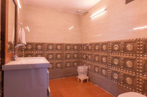 a bathroom with a sink and a toilet at Flying Sparrow Riverside Resort in Dhikuli
