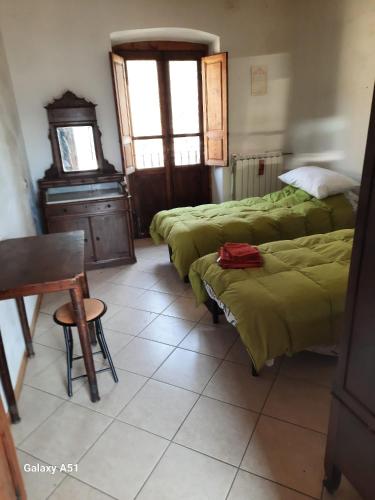 a room with three beds and a chair and a table at casa delle arti in Salutio