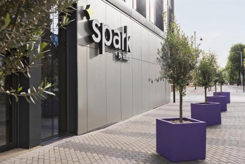 a row of potted trees in front of a store at Spark by Hilton London Romford in Romford