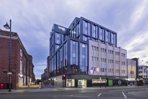 a tall glass building on a city street at Spark by Hilton London Romford in Romford
