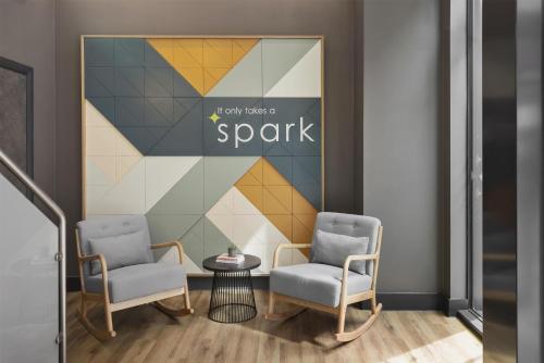 a lobby with two chairs and a sign that reads only take a spark at Spark by Hilton London Romford in Romford