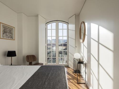 a bedroom with a bed and a large window at LSA Baixa Castelo by Numa in Lisbon