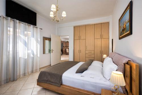 a bedroom with a large bed and a chandelier at Anchor House Santorini in Fira