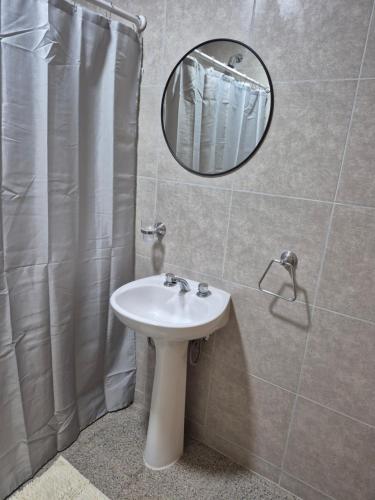 a bathroom with a sink and a mirror at CasaMora departamento céntrico con cochera gratis, 2 habitaciones in Almafuerte