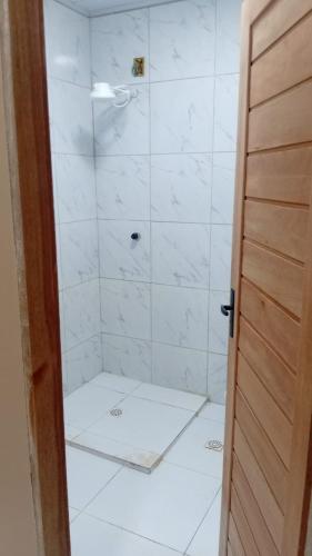 a bathroom with a shower with white tiles at Espaço Mãe Cecília in Paripueira