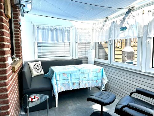 a room with a couch and a table and a window at Haus Seeblick Ferienhaus Priwall in Priwall