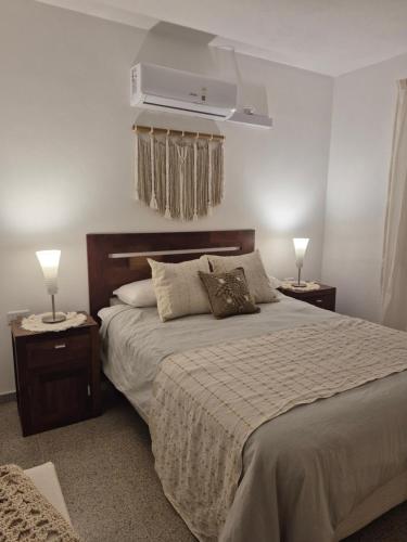a bedroom with a bed with two night stands and two lamps at CasaMora departamento céntrico con cochera gratis, 2 habitaciones in Almafuerte