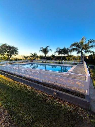 a swimming pool in a park with trees in the background at Cabañas La Soñada in Chajarí