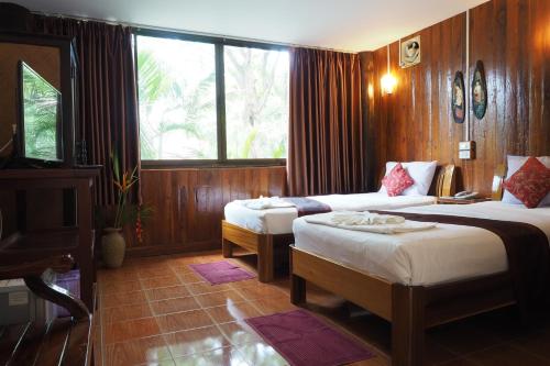 a hotel room with two beds and a window at ภูตะวัน กาญจน์ รีสอร์ท Phutawan Kan Resort in Kanchanaburi City